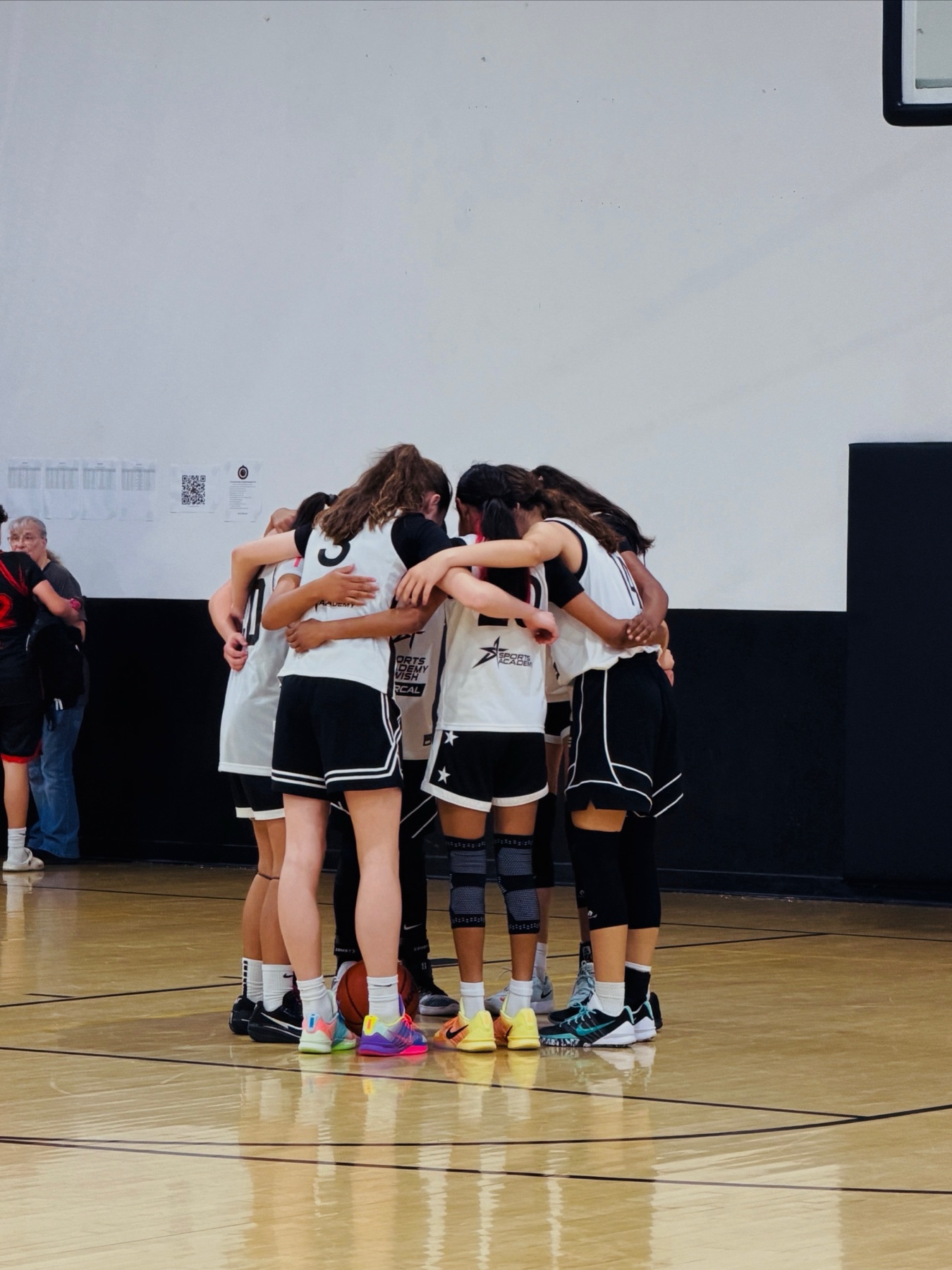 A WE team huddle before tip-off